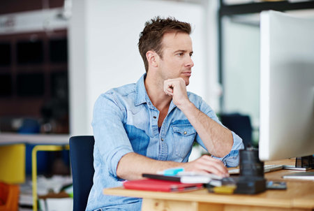 Man, office and thinking on computer with research for creativity, designs and ideas for project as...