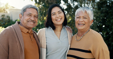 Nature, face and woman with her senior parents in a garden for family bonding together. Smile, care and portrait of female person hugging elderly man and woman in retirement with love in outdoor parkの写真素材