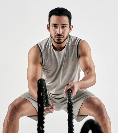 Workout, man and battle ropes in studio for muscular endurance, bicep strength or HIIT exercise....