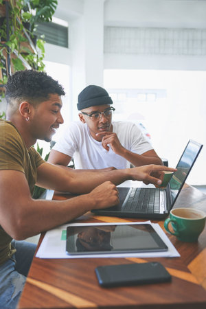 Team, research and men with laptop in coffee shop, thinking and planning for design on web or...