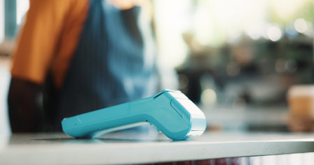 Pos machine, barista or counter with checkout system in cafe for automated payment or transaction. Person, bistro or NFC equipment on table for banking app, self service station or tip in coffee shop