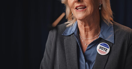 Woman, mouth and political speech at convention for democracy, press conference and election campaign. Mature politician, talking and vote badge for government, public announcement and media debrief