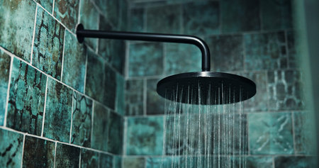 Background, cleaning and water with shower head in bathroom for hygiene, liquid or wellness. Interior, wall and spray with nozzle sprinkler in apartment for disinfection, sanitation or washing