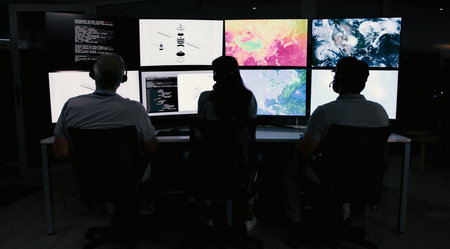 Computer screen, weather and back of people in control room for storm, research and monitor. Meteorology tracking, sounding rocket and climate change surveillance with employee in office for data