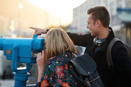 Tourism, telescope and couple in city with view on holiday for travel, vacation and trip together. Marriage, happy and man with woman for bonding, relationship and pointing for sightseeing outdoor
