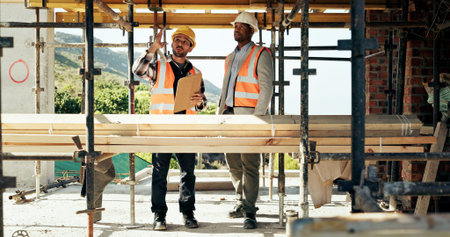 Civil engineering, team and men with clipboard, construction site and safety inspection for project. Architect, pointing and people with ideas for architecture, talking and scaffolding at building