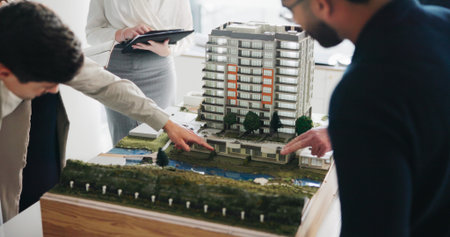 Property development, meeting and people in office with model, feedback or discussion in design review. Building, layout or architects with prototype, structure plan or team evaluation on investment.