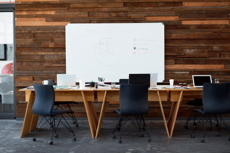 Empty office, table and tech for coworking startup, insurance pie chart or wealth management. Whiteboard, laptop or minimalist interior for debt consolidation data, banking agency or workplace setup