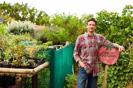 Portrait, garden or happy man with sign for food, natural outdoor growth or sustainability. Male person, environmentalist or community gardener with smile, plant or harvest for agriculture or produce