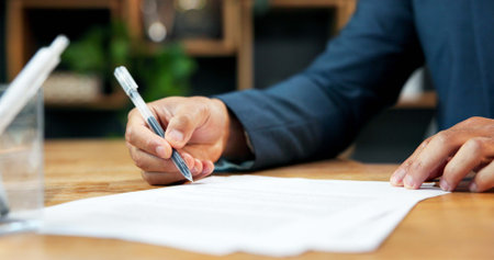 Hands, person and paperwork signature in office for legal agreement, insurance application or deal. Business, document and filing contract, signing coverage policy or writing on form for registration