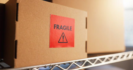 Warehouse, empty and box with fragile label for shipping, supply chain and inventory with warning. Cardboard, workshop and caution on package, parcel and stock for distribution, shipment or logistics