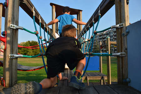 two children playing on a wind-up toy in a playgroundの写真素材