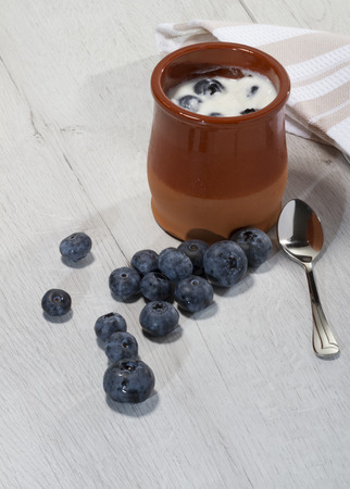 homemade yogourt with blueberries in a traditional clay potの写真素材