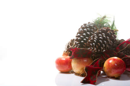 beautiful Christmas composition with pinecones and pomegranates on a white backgroundの写真素材