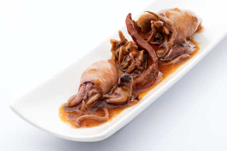 snack squids conserve in hot pepper sauce on a white backgroundの写真素材