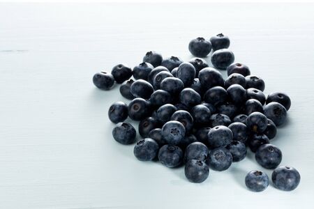 blueberries on a soft blue wooden table. Free space for textの写真素材