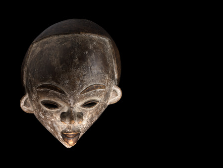 african culture, carved mask on a black backgroundの写真素材