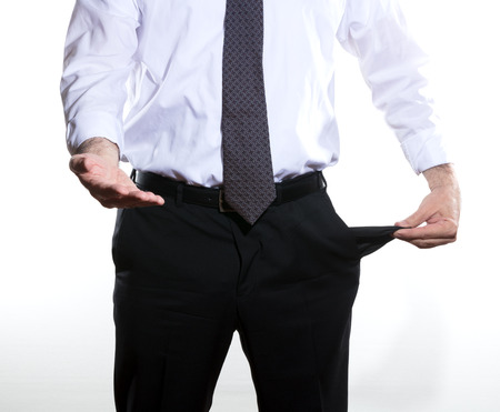 businessman showing his pockect empty, asking for money, he wears a gray tie and trousers and white shirtの写真素材