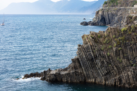 national park of the Cinque Terre, photo of the coast from the village of Vernazza with a sailboat and the walk by the cliffの写真素材