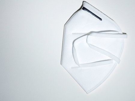 personal hygienic mask color white with metallic nose adapter on white background, with free space...