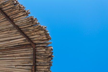 view of the tip o a straw umbrella and clear summer sky. point of viewの写真素材