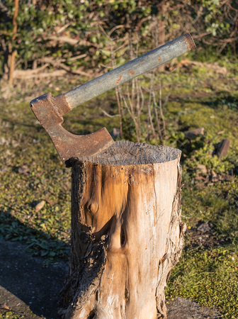 rusty steel axe embedded in a cut logの写真素材