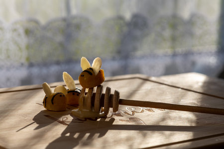 3 marzipan bees on a honey spoon on the kitchen table. Funny bees.