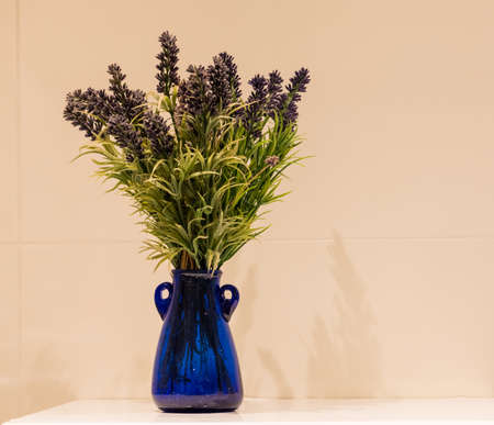 Lavender in a blue glass vase on a calm background.の写真素材