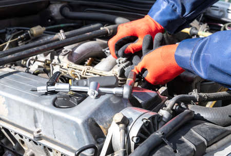 Repair, engine, screw on, workshop red gloves, screwdriver and tensioner.の写真素材