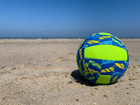 A sandy beach holding a football ball.の写真素材