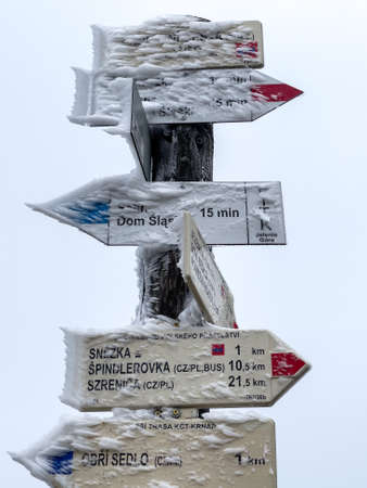 Ice on a signpost in winter. Mountains.の写真素材