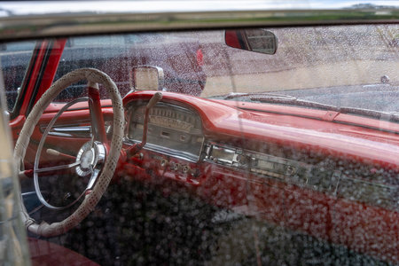 Interior of an American classic car through the side window with many raindrops.の写真素材