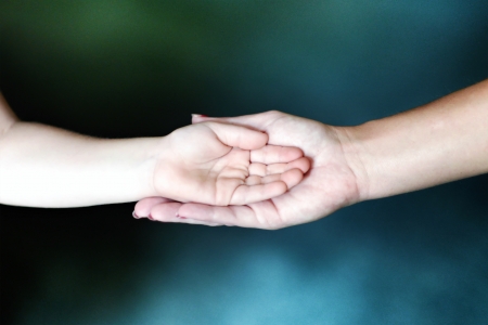 Child s hand in an adult s hand suggesting motherly love or a teacher s guidance の写真素材