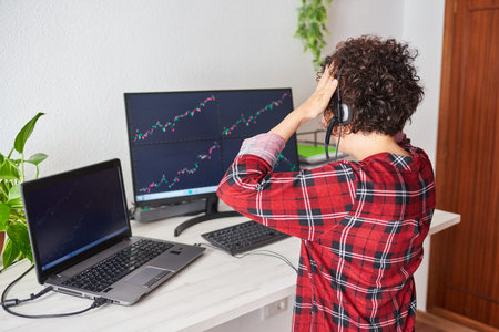 An unrecognizable woman who is a trader puts her hands on her head for a bad investment