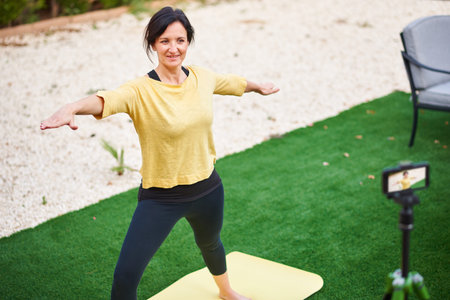A female content creator records herself doing yoga for her social media channel
