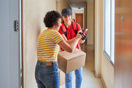 Delivery woman using mobile phone with customer