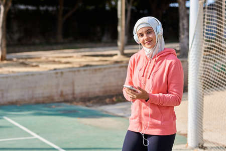 Muslim young woman with headphones taking a breakの写真素材