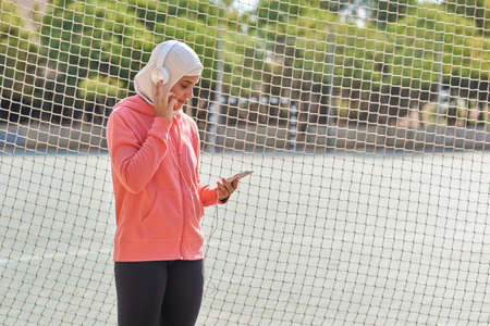 Muslim young woman with headphones taking a breakの写真素材