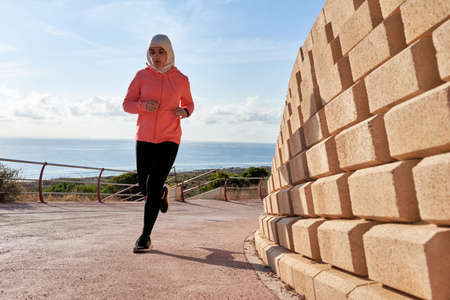 Muslim young woman wears a hijab while runningの写真素材