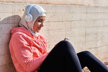 Muslim young woman with headphones taking a breakの写真素材