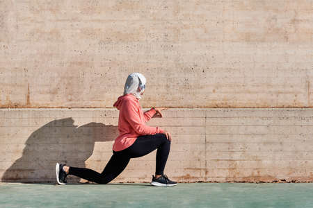 Unrecognizable woman with muslim sport wear stretchingの写真素材