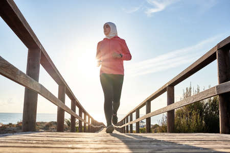 Young muslim runner training on the beachの写真素材
