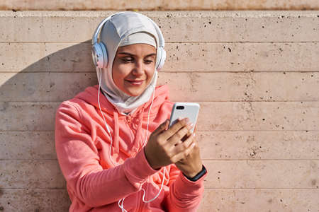 Muslim young woman with headphones taking a breakの写真素材
