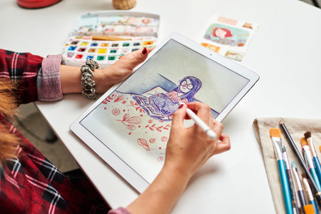 Caucasian female artist illustrator painting drawing on touch digital tablet with stylus