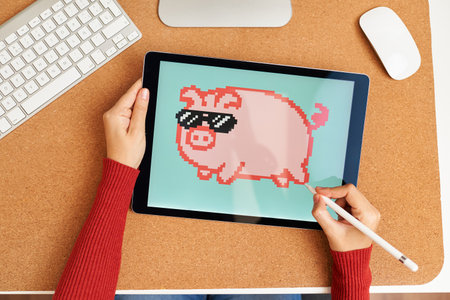 NFT artist painting on a digital tablet in his home officeの写真素材