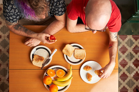 Top view of a table in the kitchen with two gay men having breakfastの写真素材