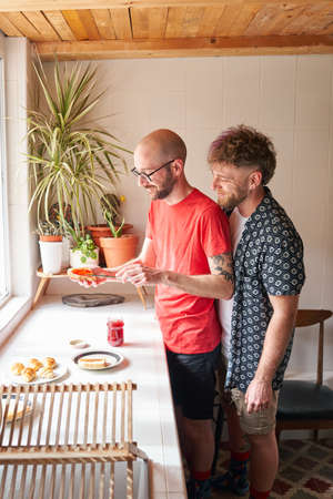 Gay couple in the kitchen making breakfastの写真素材