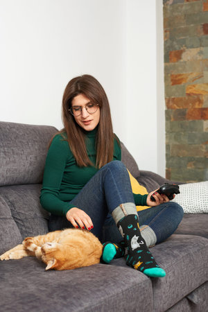 Woman caresses her cat on the sofa