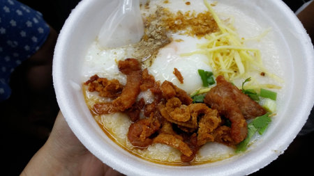 rice porridge, rice gruel or congee with pork, egg, sliced ginger and vegetable