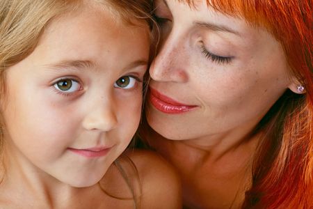 Close-up portrait of tender mother with beautiful little daughterの写真素材